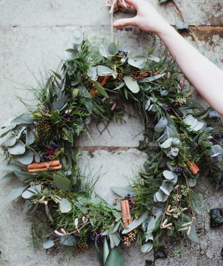 prírodný veniec vyrobený z konárov, listov a rastlín ozdobený škoricovými tyčinkami veniec-vianočný-drotár-nápady-prírodný-vzhľad-materiály-škorica-čučoriedky-vetvičky-zelená