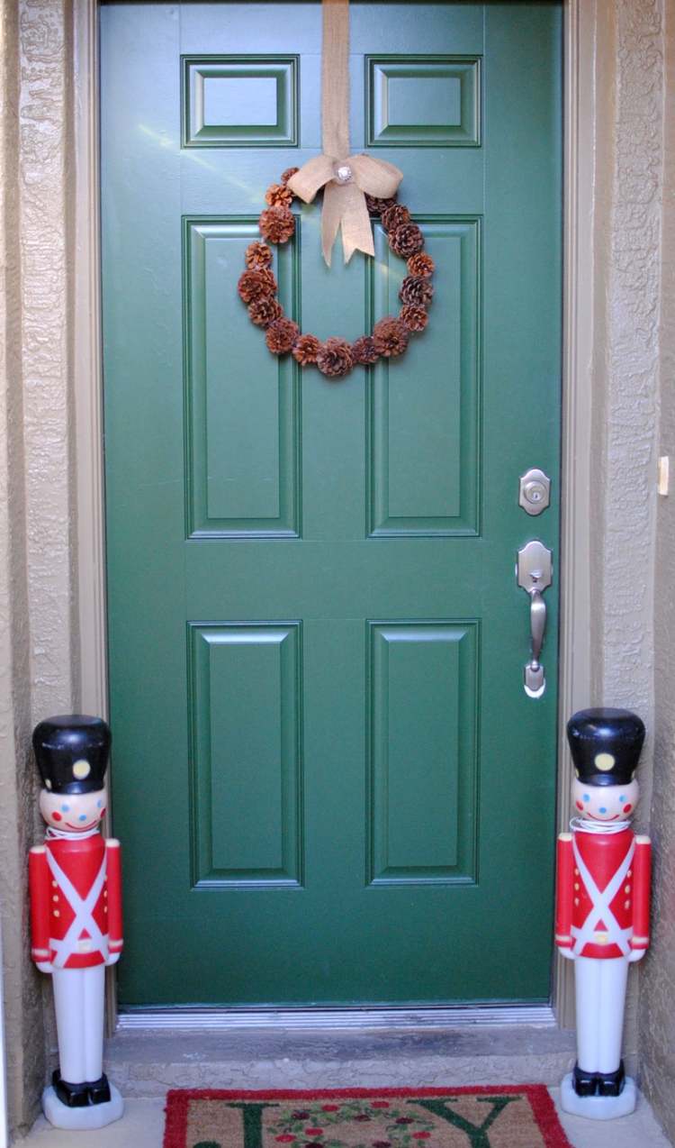 krásny dverový veniec zo šišiek zavesený na zelených vchodových dverách veniec-na-vianoce-urobte-si-šišky-dom-dvere-deco-maennchen-green