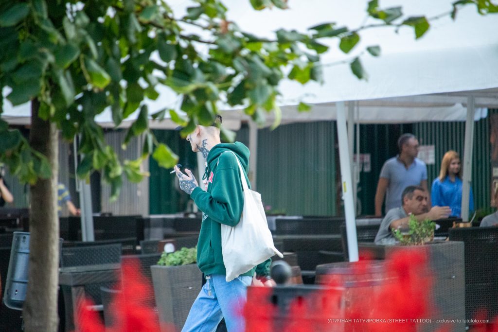 Tatuaż z sierpem na twarzy faceta i napisem NESS z twarzą diabła na dłoni - 17.09.2020 - 1