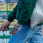 Tatuaż z sierpem na twarzy faceta i napisem NESS z twarzą diabła na dłoni - 17.09.2020 - 10