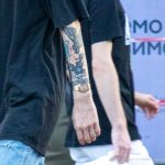 Tatuaż bransoletka ze wzorem i małymi rysunkami na lewą rękę młodego mężczyzny - 17.09.2020 - 2