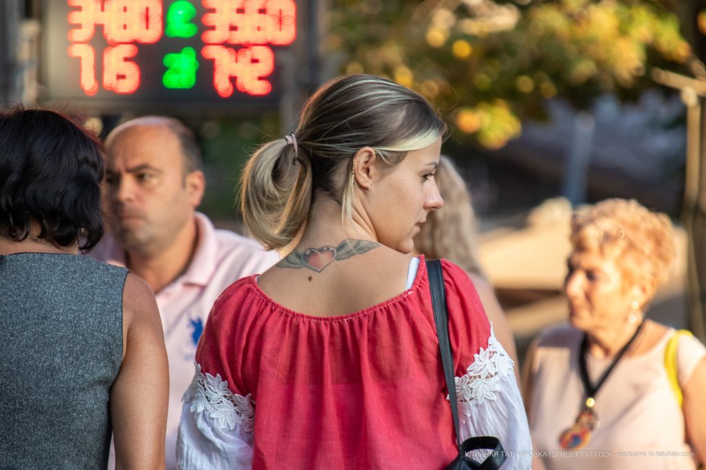 وشم على شكل قلب بأجنحة على الظهر أسفل رقبة فتاة - وشم شارع وشم - 21.09.