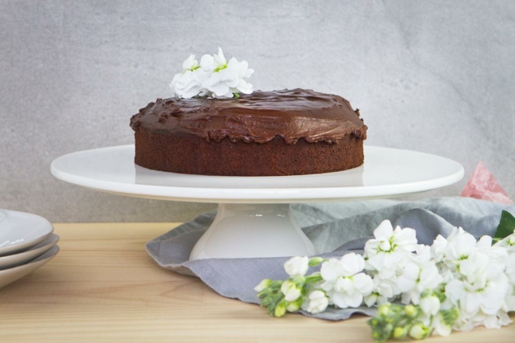 Čokoládová torta ozdobená bielymi kvetmi vegánsko-čokoládový koláč-bezlepková-ryžová múka-surový trstinový cukor-sójové mlieko-kvet-koláč-tanier-tanier