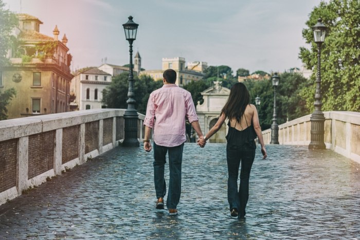 kráčať rím držiaci sa za ruky pár láska most mesto
