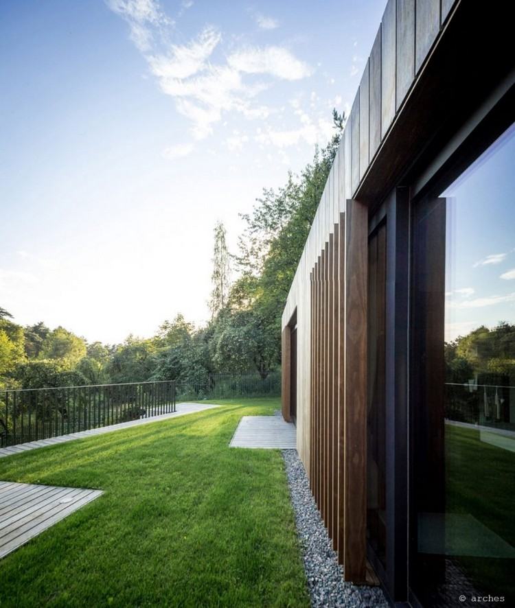 Výhľad na trávnik a les zvislá-drevená fasáda-drevené dosky-rolety-okná