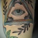 Mindent látó szem háromszög tetoválás a vállán