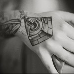 Mindent látó szem tetoválás egy nő kezén