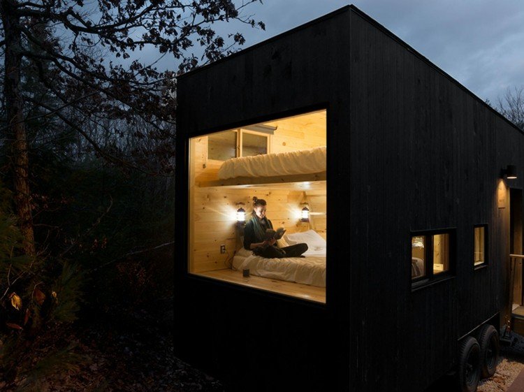 lesný dom z dreva v noci únikové okná predné postele