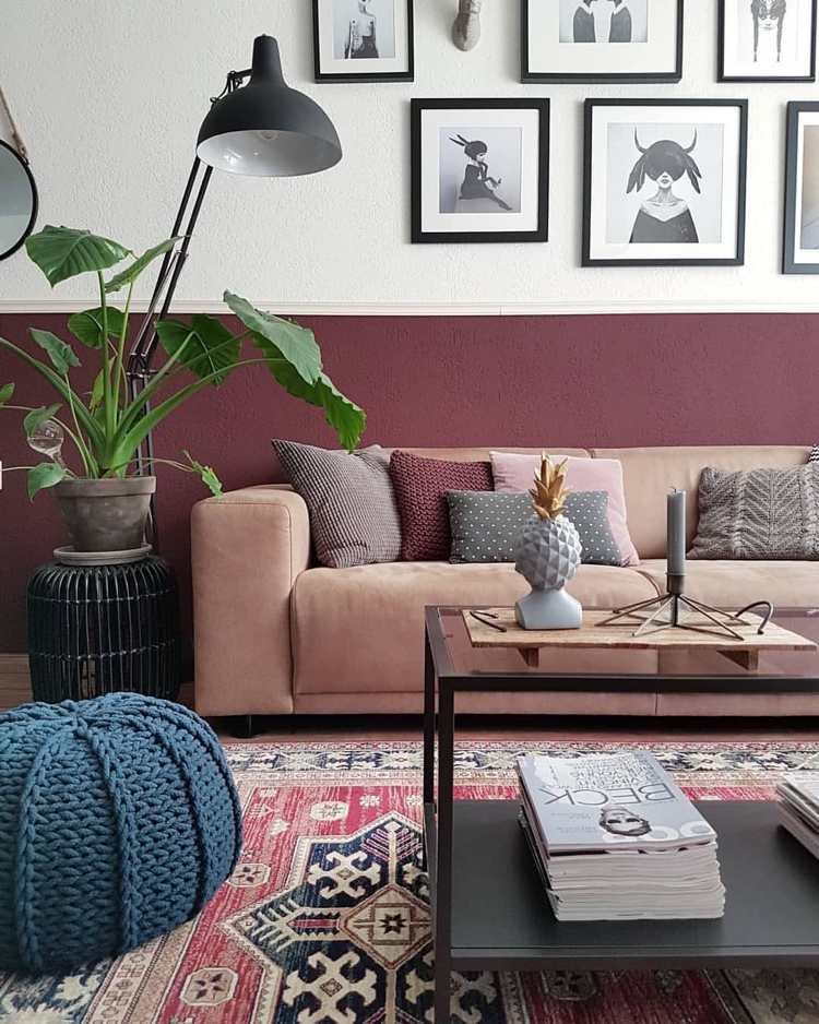 Stena vymaľovaná do polovice červenej farby s galériou obrázkov nad gaučom