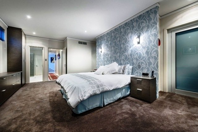 Spálňa v prírodných tónoch-veľkoryso rezaná akcentovaná stena je obložená papierom prírodné tóny-koberce-veľkoryso-spálne-akcent na stenu-vytapetované