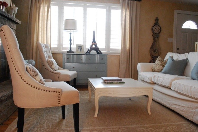 Obývacia izba s čalúneným nábytkom a komodou v svetlo modrej farbe farba steny-piesková sedačka-obývačka-vankúš-biely-konferenčný stolík-koberec