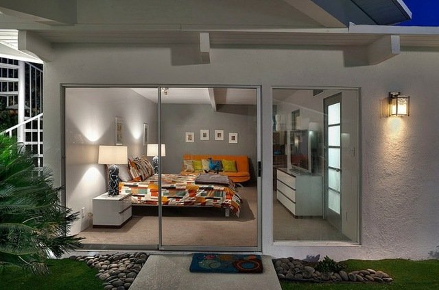 Spálňa zariadená farebným prehozom oranžová pohovka sivé steny Obrázky sivej steny s oranžovou perinou