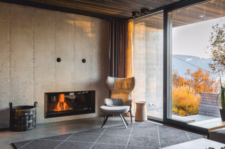 odhalená betónová stena komínová inštalácia kreslo koberec