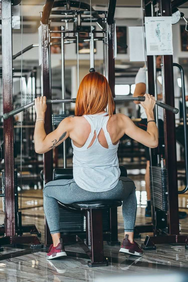 telocvičňa čo na seba žena cvičiaca posilňovňa športové podprsenky racerback tielkové legíny a tenisky