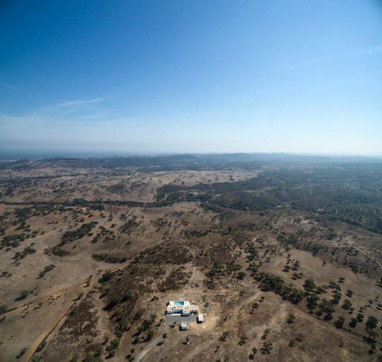 Fasáda bieleho domu dom-rovinatý-pozemok-obklopený prírodou