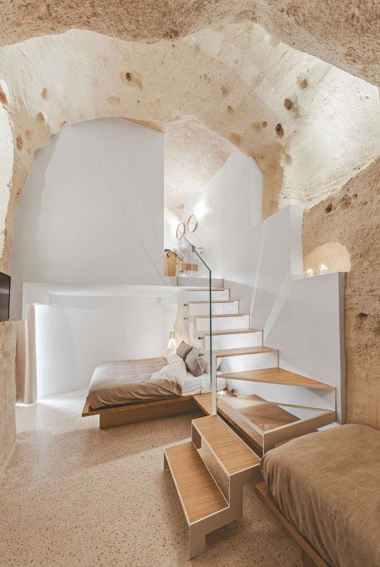 nie typická hotelová izba na dvoch úrovniach biela farba na stenu-prírodný drevený nábytok-vápenec-schody-manzardová-hotelová izba