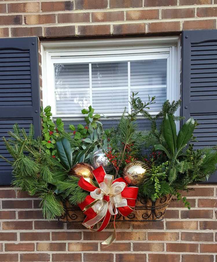 Vianočná dekorácia Vonkajší parapet vonku, kvetinový box ozdobený na Vianoce červenou mašľou a vianočnými guľami