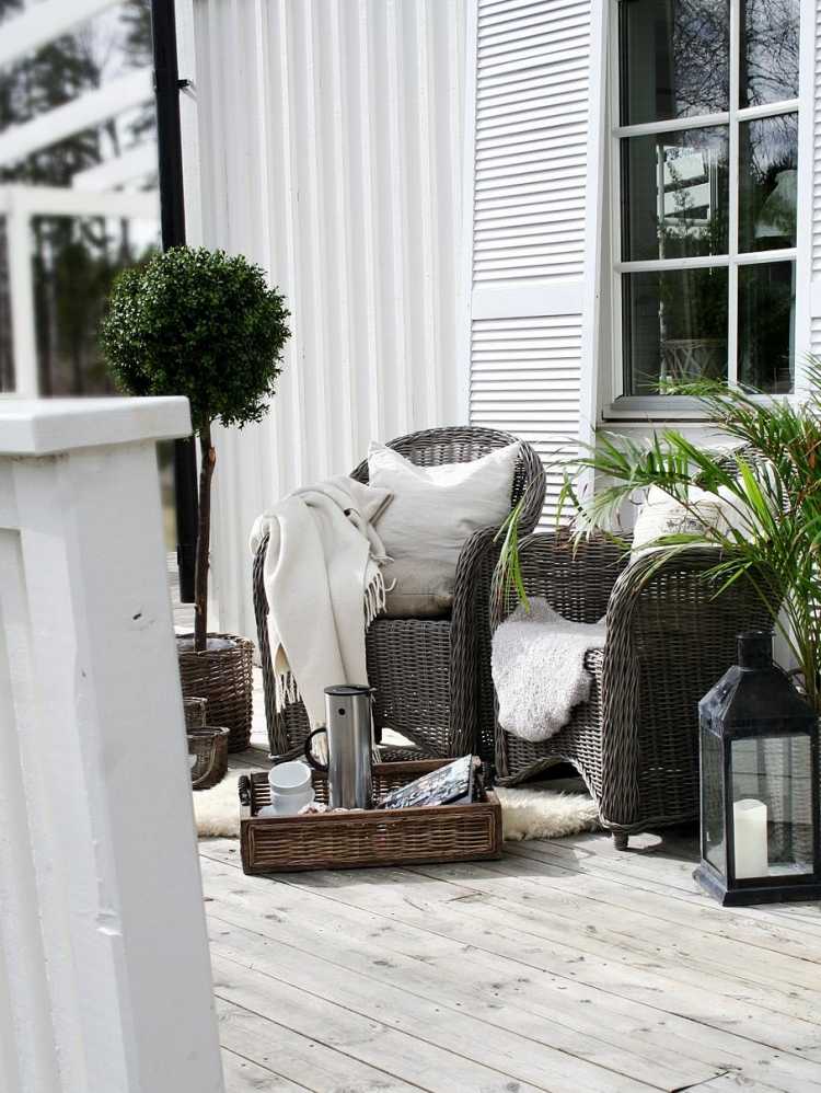 Veranda so elegantným záhradným nábytkom, útulnou dekou a veľkou lampou na sviečky Vianočné dekorácie-záhradné nápady-veranda-ratan-záhradný nábytok-lampa na sviečku-obliečka na vankúš