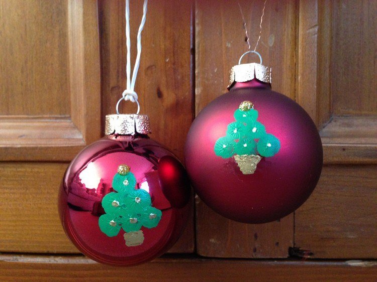 Deti maľujú gule na vianočný stromček z odtlačkov prstov