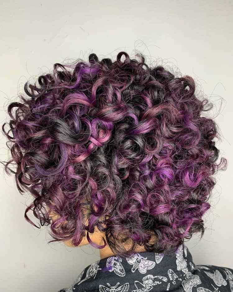 Lilac melíruje na tmavohnedých kučeravých vlasoch