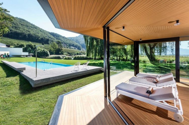 moderný pavilón s pevnou strechou a bazénom na záhradných ležadlách