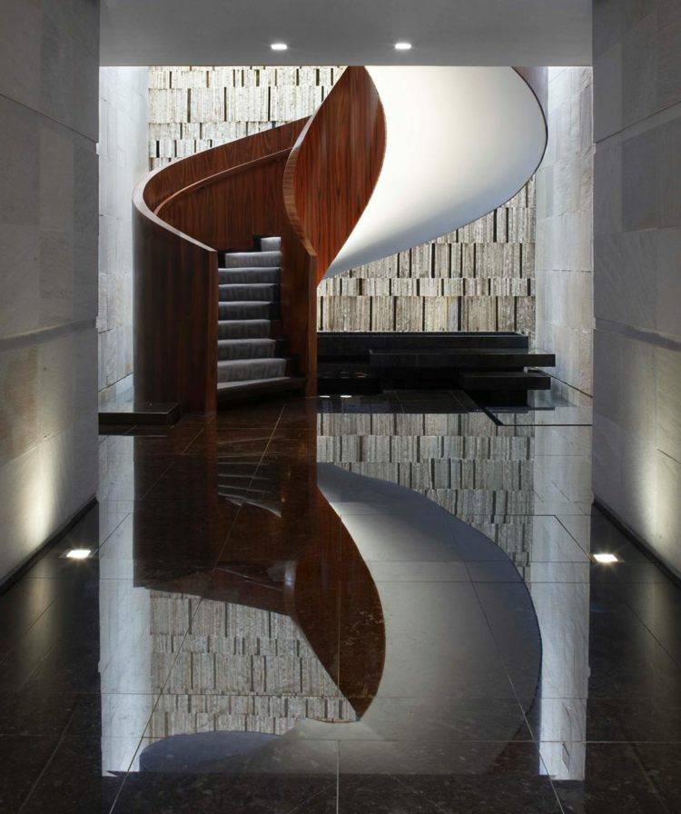 drevené točité schodisko vo vnútri biele nášľapné podložky zábradlie z tmavého dreva