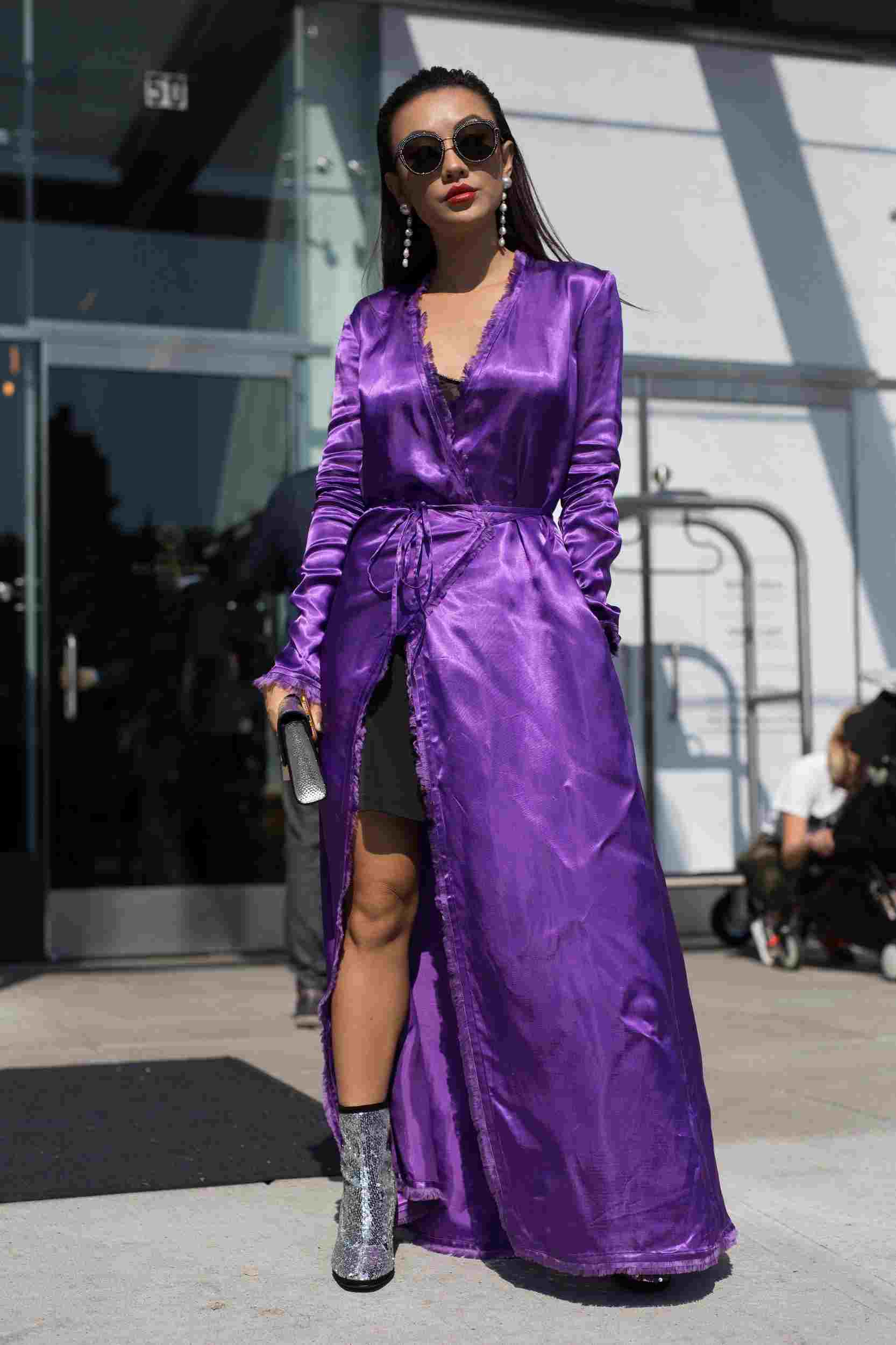 Saténové zavinovacie šaty kombinujú kabátové členkové čižmy s lesklými okrúhlymi slnečnými okuliarmi v lete