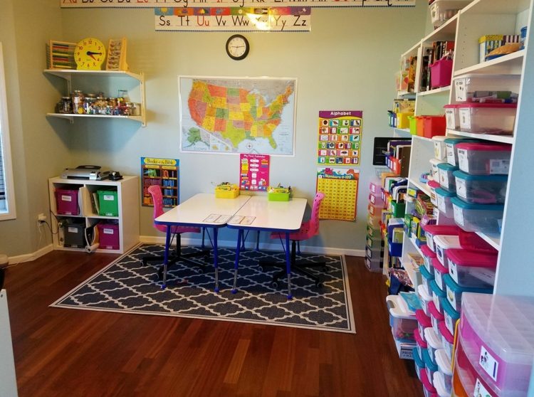 Dva stolíky na stene ako písacie stoly a polica s krabicami na odkladanie