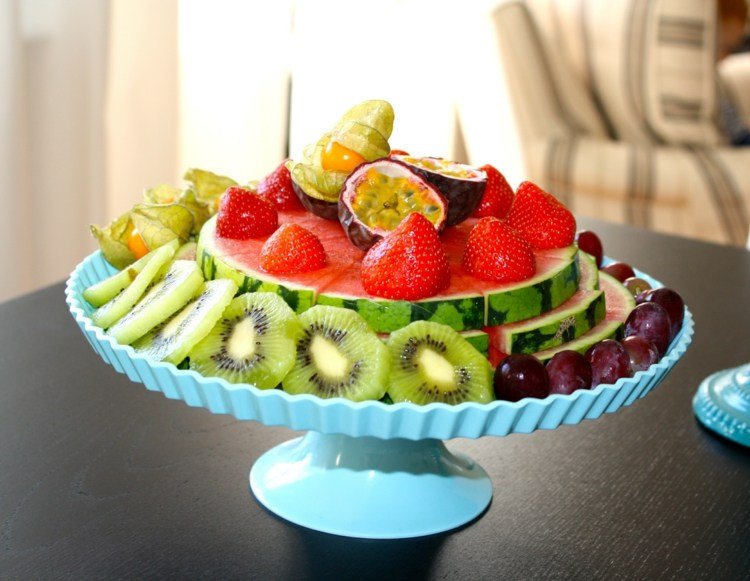 Melóny v osminách na stojane na tortu, ozdobené sezónnym ovocím