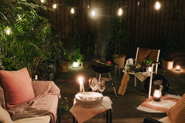 Miesto pre gril so stoličkami, rozprávkovými svetlami a rastlinami