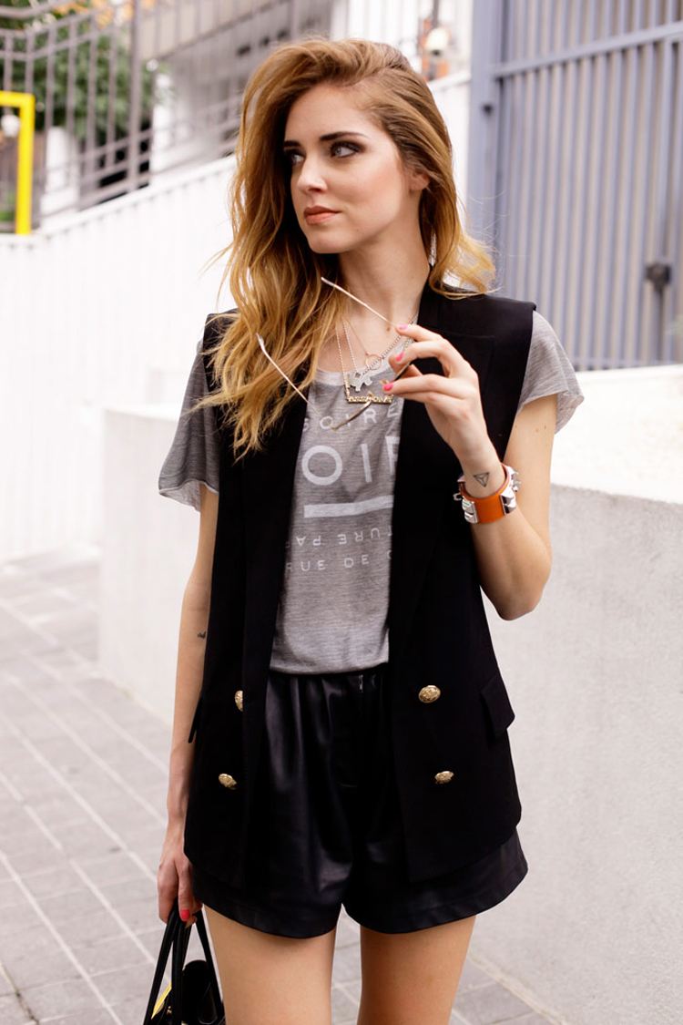 Vesta Blazer kombinuje čierne šortky, tričko, medové vlasy a oblečenie v lete