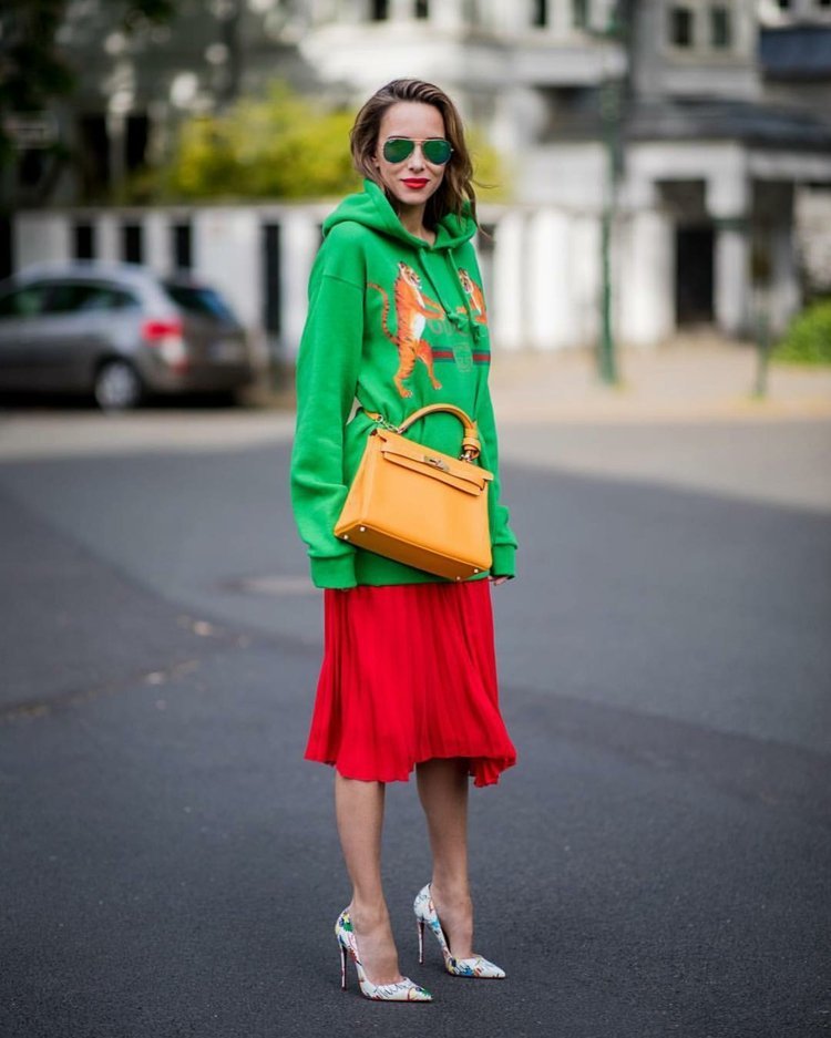 Skladaná sukňa kombinuje mikiny s veľkými podpätkami a športovými elegantnými outfitmi