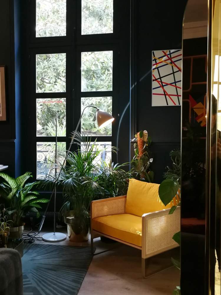 Kreslo s prútím a žltým čalúnením ako farebný akcent v tmavej miestnosti