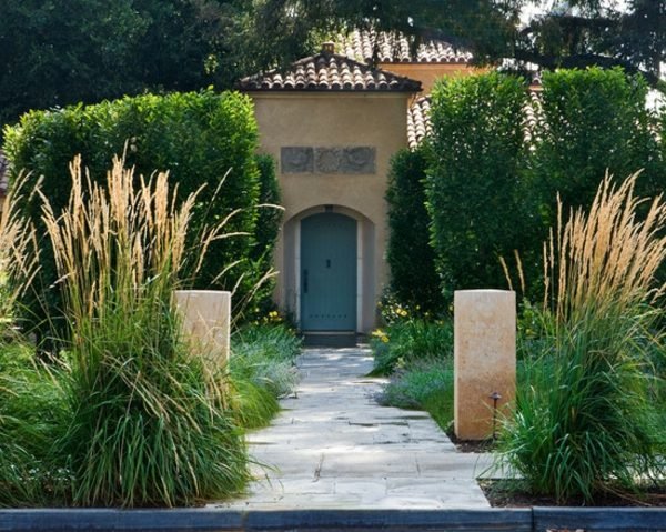 vchod do domu z kamennej steny v stredomorskej záhrade Kamenný múr vchod do domu pampa tráva