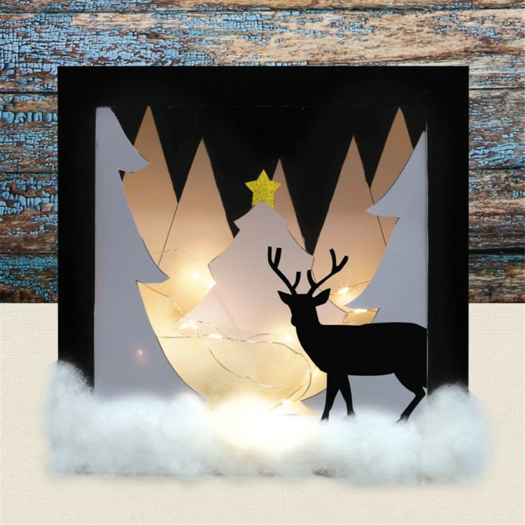 Nápad na zasneženú krajinu z papiera so stromami a jeleňmi