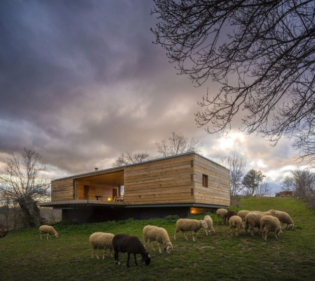 Drevený pavilón na obývanie plochých strešných betónových základov vo svahu