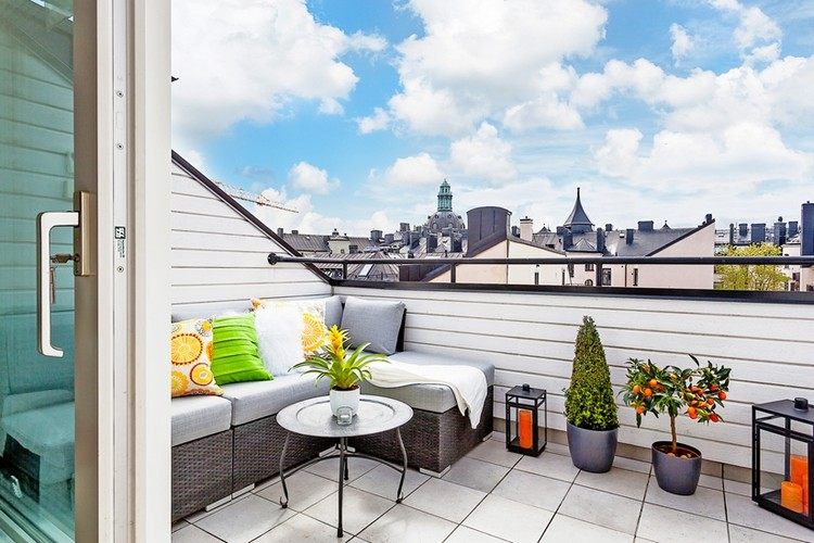 Dizajn balkóna sivá-dlažba-ratan-rohová sedacia súprava-lampáše na sviečky-pomaranč-strom-kvetináč