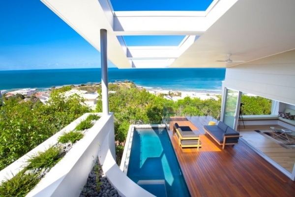 Otvorený dom s drevenou terasou s výhľadom na more Otvorená drevená paluba s výhľadom na oceán a výhľadom na domov