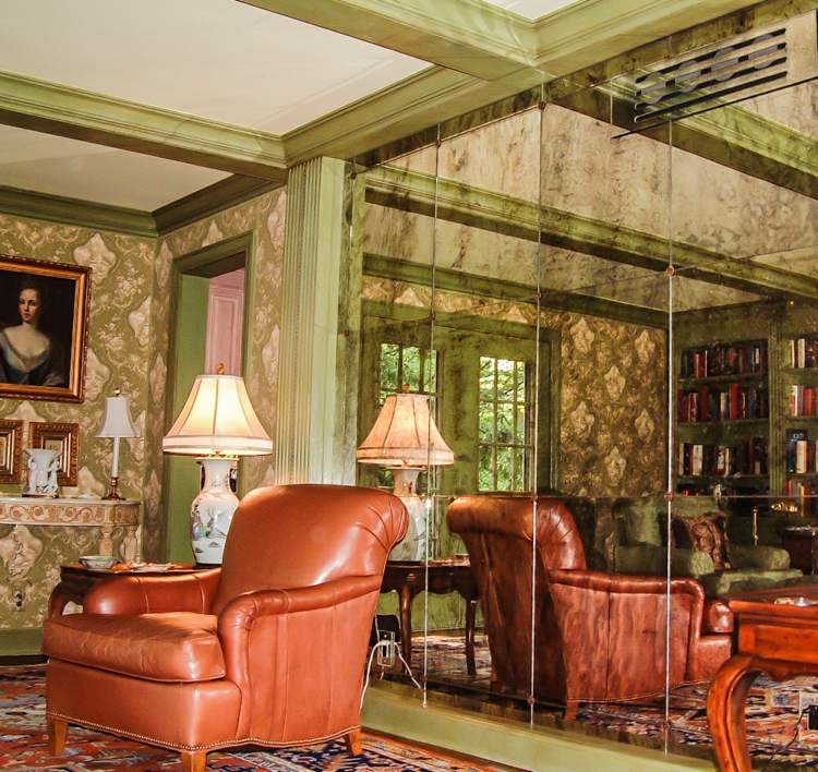 Izba so zrkadlovou stenou - Luxusne zariadená obývačka s koženým kreslom a tapetou zrkadlová stena ušľachtilý dizajn kožené kreslo vintage obývačka zelený bar