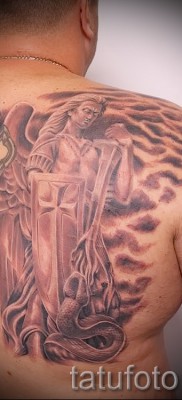 Снимка на татуировката Архангел Михаил с кръст и щит на дясната лопатка на мъжа