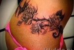 Fekete rózsa tetoválás a lány derekán - bugyi közelében