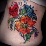 tetoválás színes virágokkal és pillangó oldalán