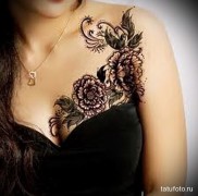 fekete virág tetoválás a mellkason és a vállán