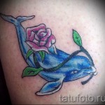 وشم دولفين يحمل زهرة في فمه