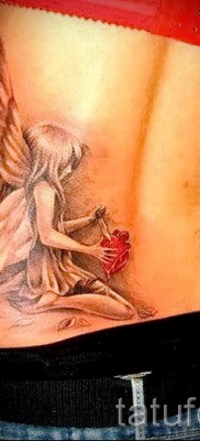 Tündér tetoválás késsel a szívben - dolgozzon egy karcsú lány alsó hátán