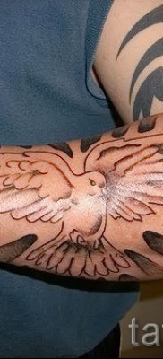 Снимка на татуировка на гълъб на предмишницата на човек