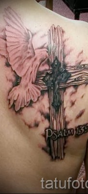 Снимка на татуировка с гълъб и кръст върху рамото на мъж