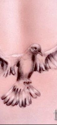 Снимка на татуировка на гълъб над задните части на момиче (в долната част на гърба)