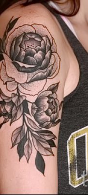 A kamélia tetoválás hűvös változata a fotón egy cikkhez, amely a kamélia virágmintájának értelmezéséről szól egy tetoválásban