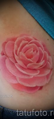 A kamélia tetoválás érdekes változata a fotón az anyaghoz, amely a kamélia virágmintájának jelentését jelenti a tetoválásban